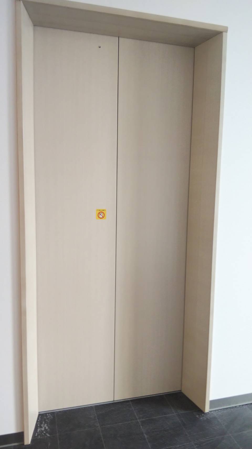 エレベーターの三方枠に手書き木目調塗装